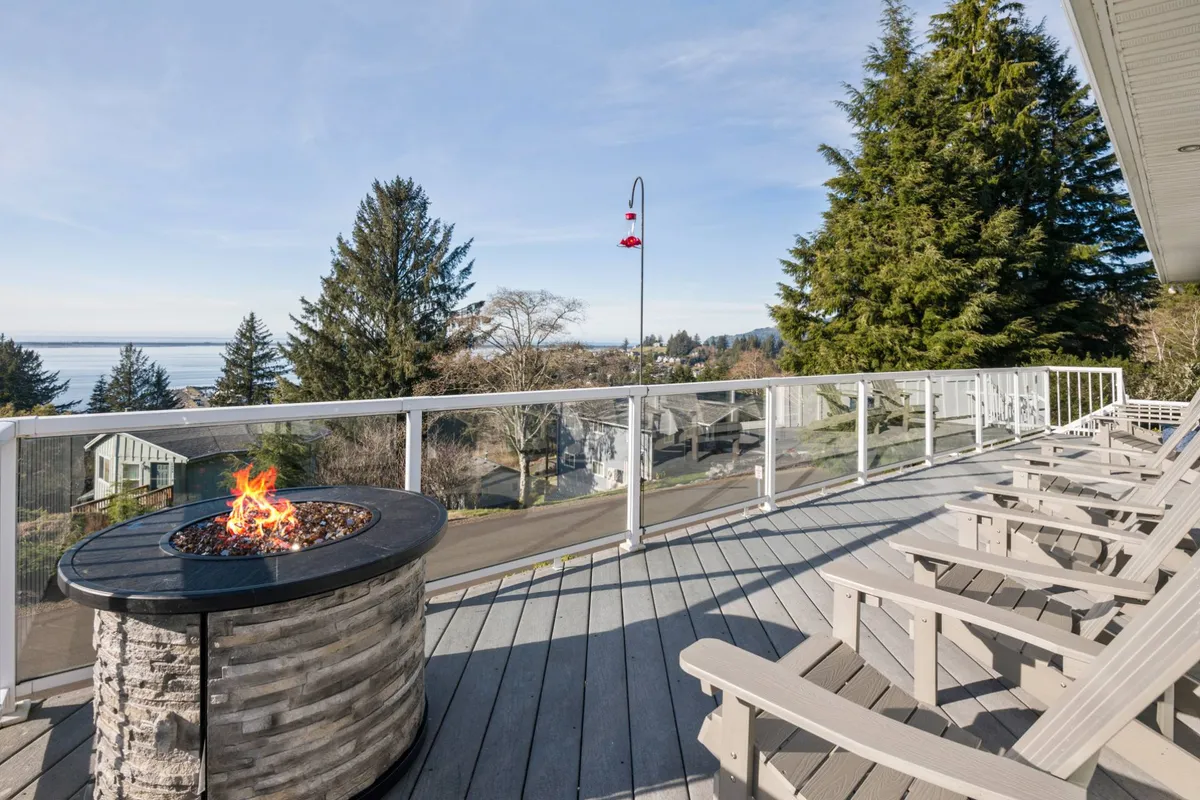 This image showcases the villa's exterior fire pit area, complete with Adirondack chairs overlooking the tranquil waters. The scene suggests a peaceful spot to relax after a day of pet-friendly adventures, with the added warmth of the fire for cozy evenings.